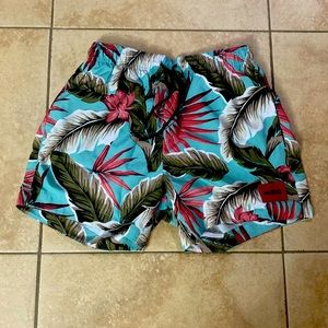 These are Hugo Boss swim trunks that are colorful with palm leaves all over.